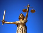 A bronze statue of Lady Justice holding a sword and scales.