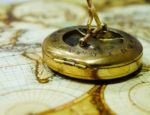 An antique compass on a map