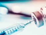 A close up of a syringe extracting medicine from a vial